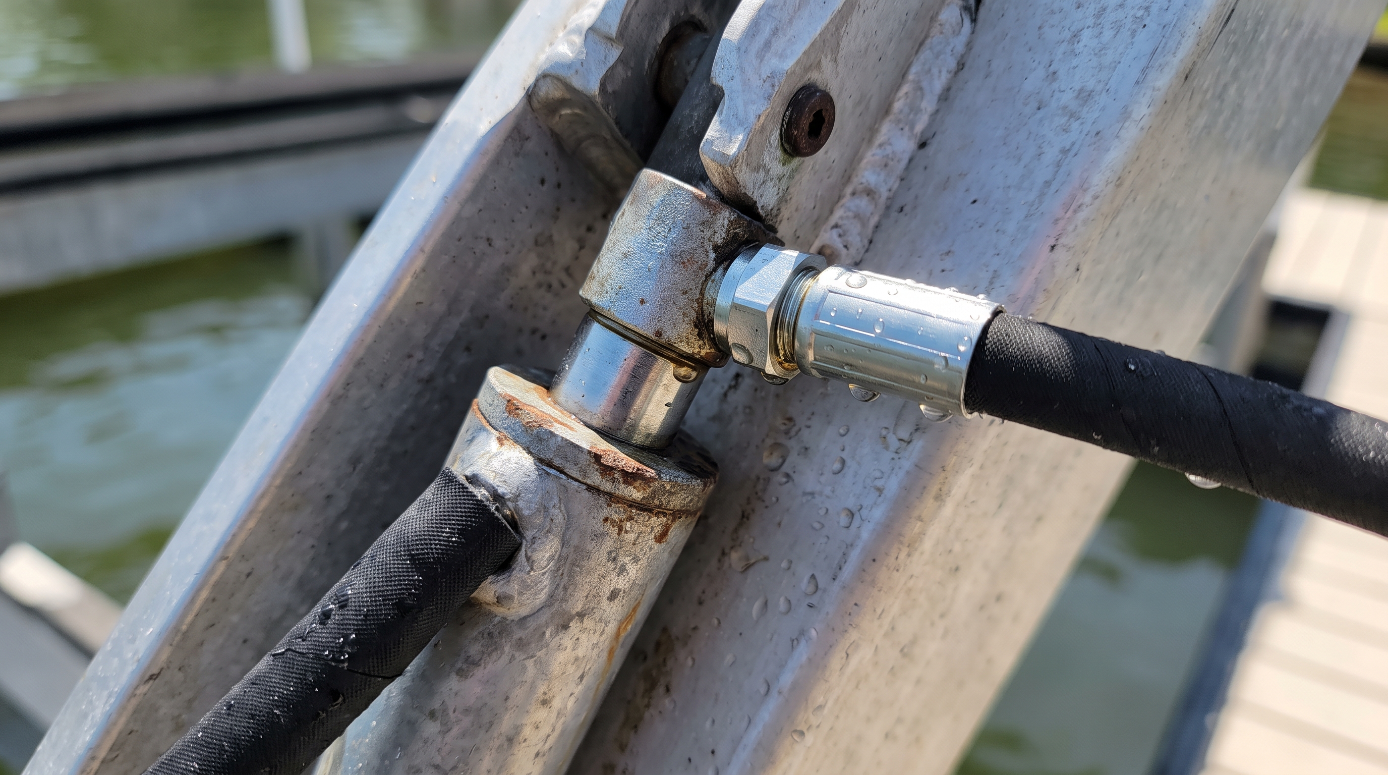 Hydraulic cylinder and hose fittings on a boat lift arm